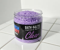Jar of purple bath salts with a label on a white surface