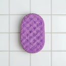 Purple textured sponge on a white tile background